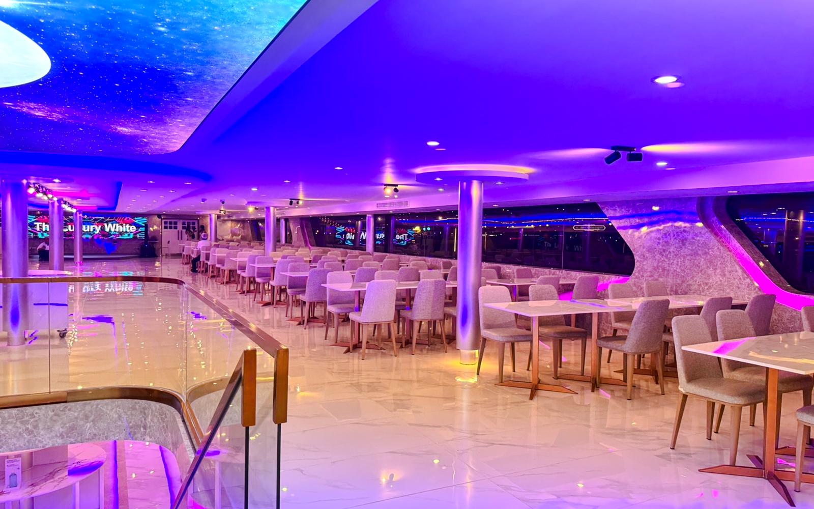 Interiors of The Luxury White Cruise ship with elegant dining area and ambient lighting.