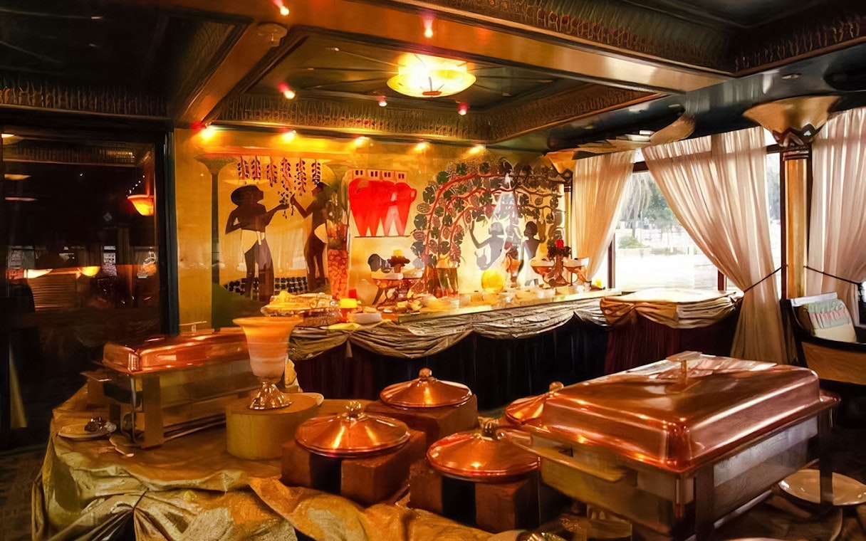 Buffet setup on a Nile dinner cruise in Cairo with Egyptian-themed decor.