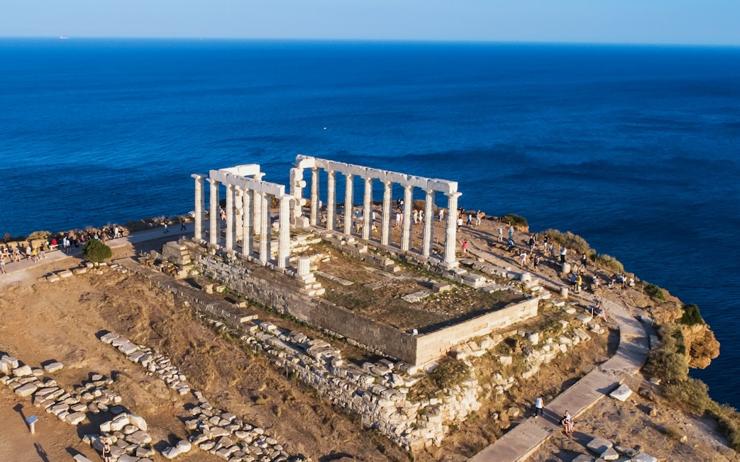 Aerial view of the Temple of Poseidon at Cape Sounio, Attica, Greece, overlooking the sea.