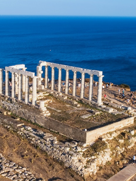 Aerial view of the Temple of Poseidon at Cape Sounio, Attica, Greece, overlooking the sea.
