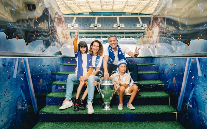Visitors posing with a trophy at FC Porto stadium museum.