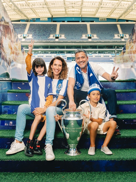 Visitors posing with a trophy at FC Porto stadium museum.