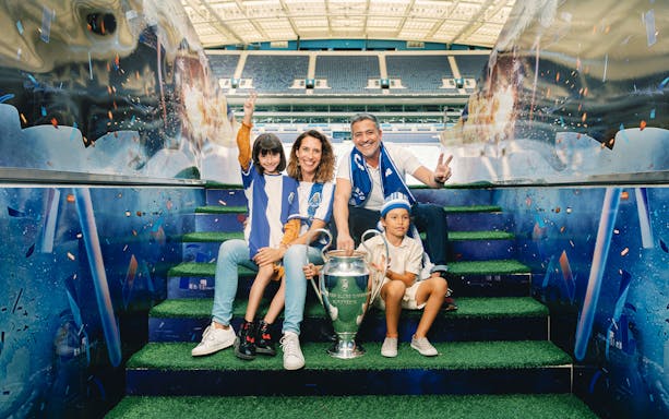 Visitors posing with a trophy at FC Porto stadium museum.