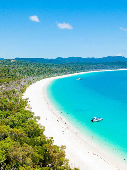 Aerial view of Whitehaven Beach with turquoise water and a boat, Whitsundays, Australia.