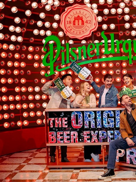 Group enjoying the Pilsner Urquell Experience in Prague with beer-themed props.