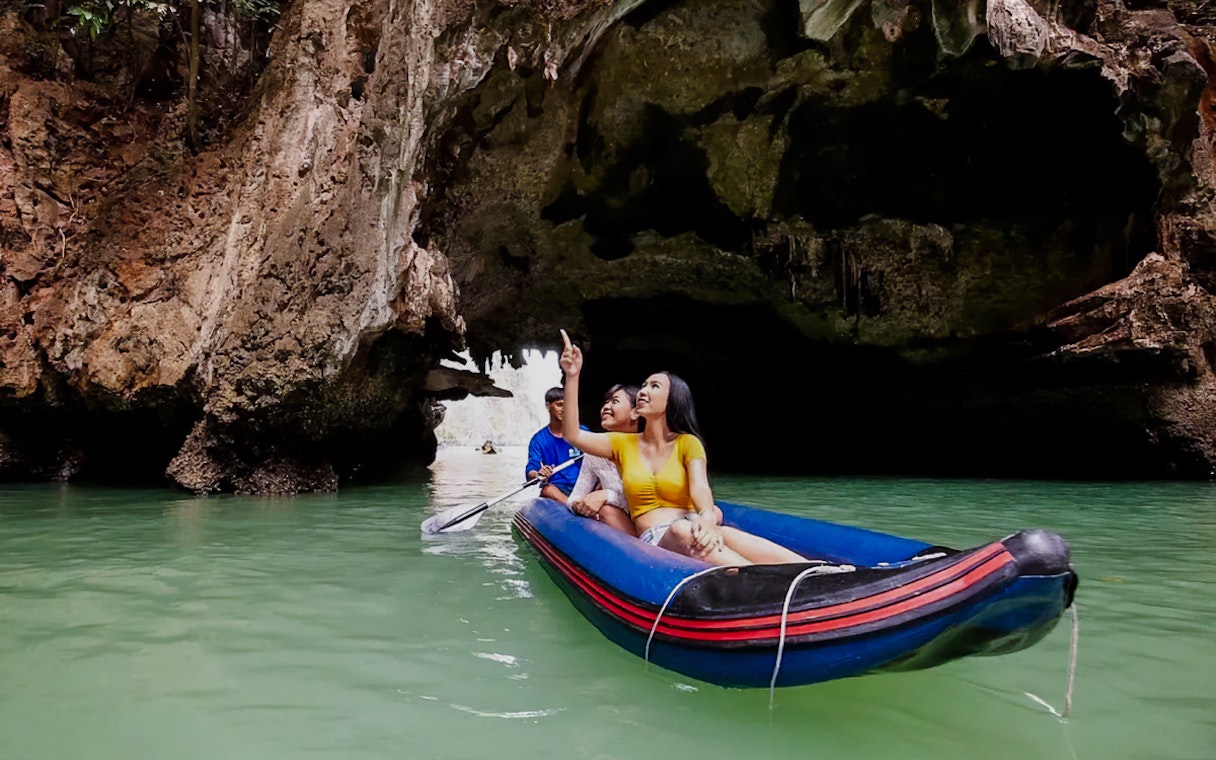 Canoeing through limestone caves at Talu Island, Thailand.