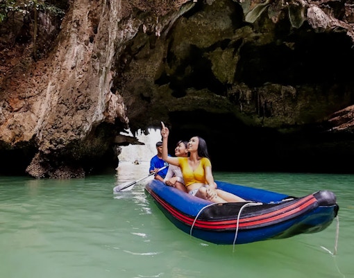 Canoeing through limestone caves at Talu Island, Thailand.