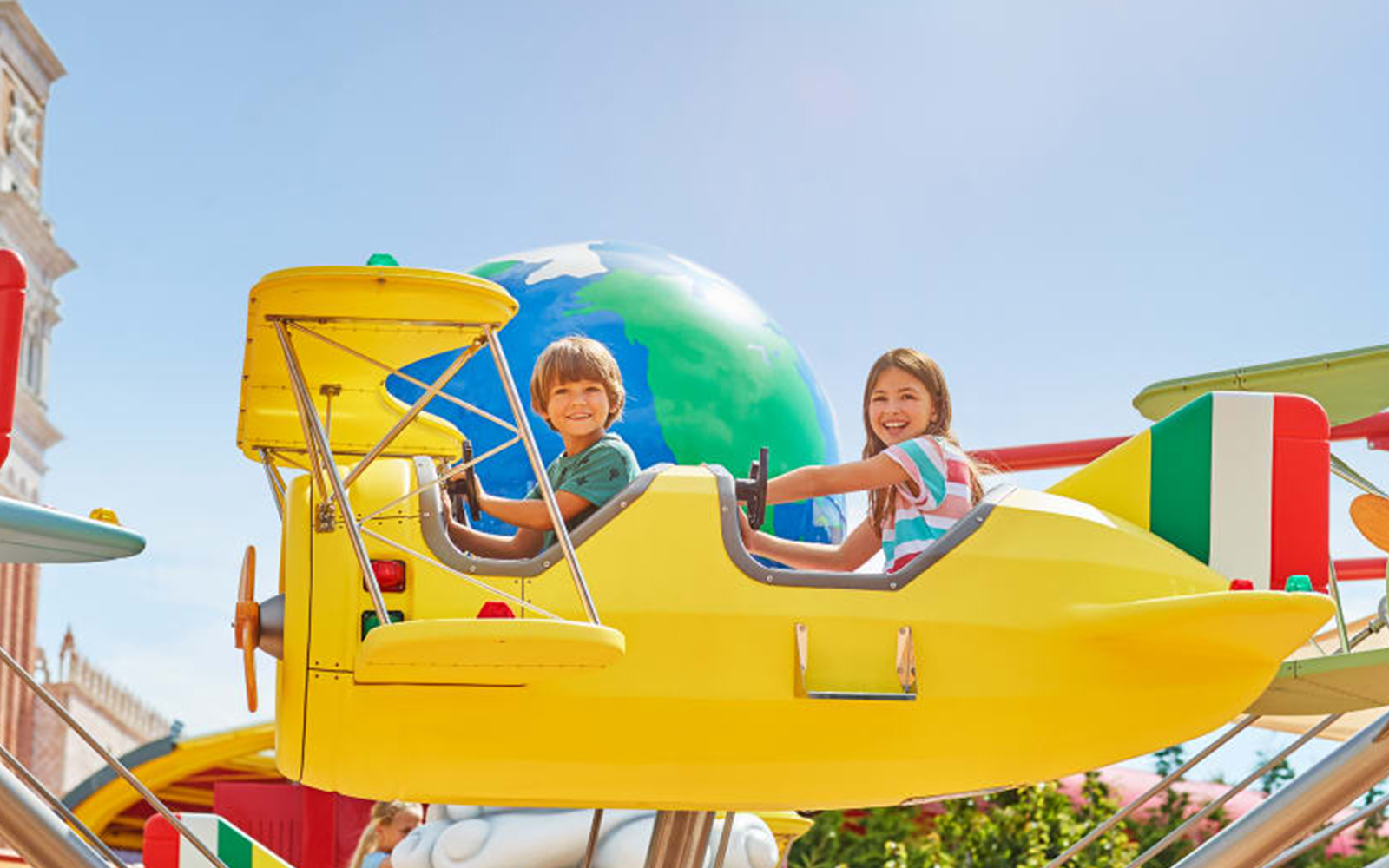 Kids enjoying on yellow coloured Flying Race Ride Port Aventura