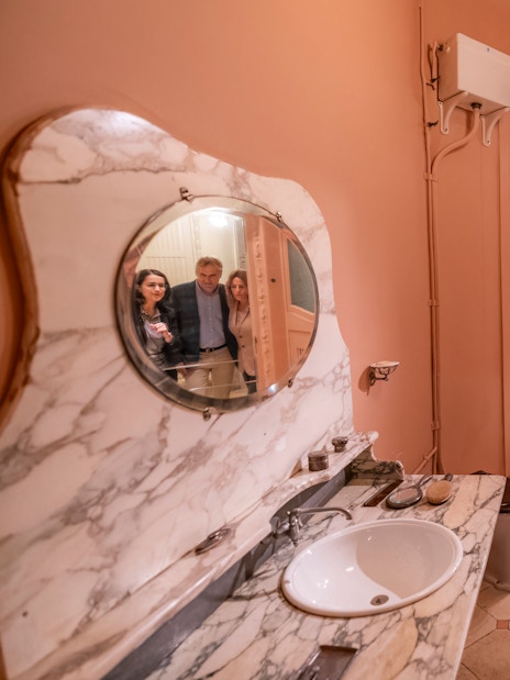 Tourists with guide in Casa Mila washroom, Barcelona.
