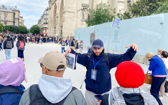 Tour guide leading a group near Notre-Dame Cathedral in Paris.
