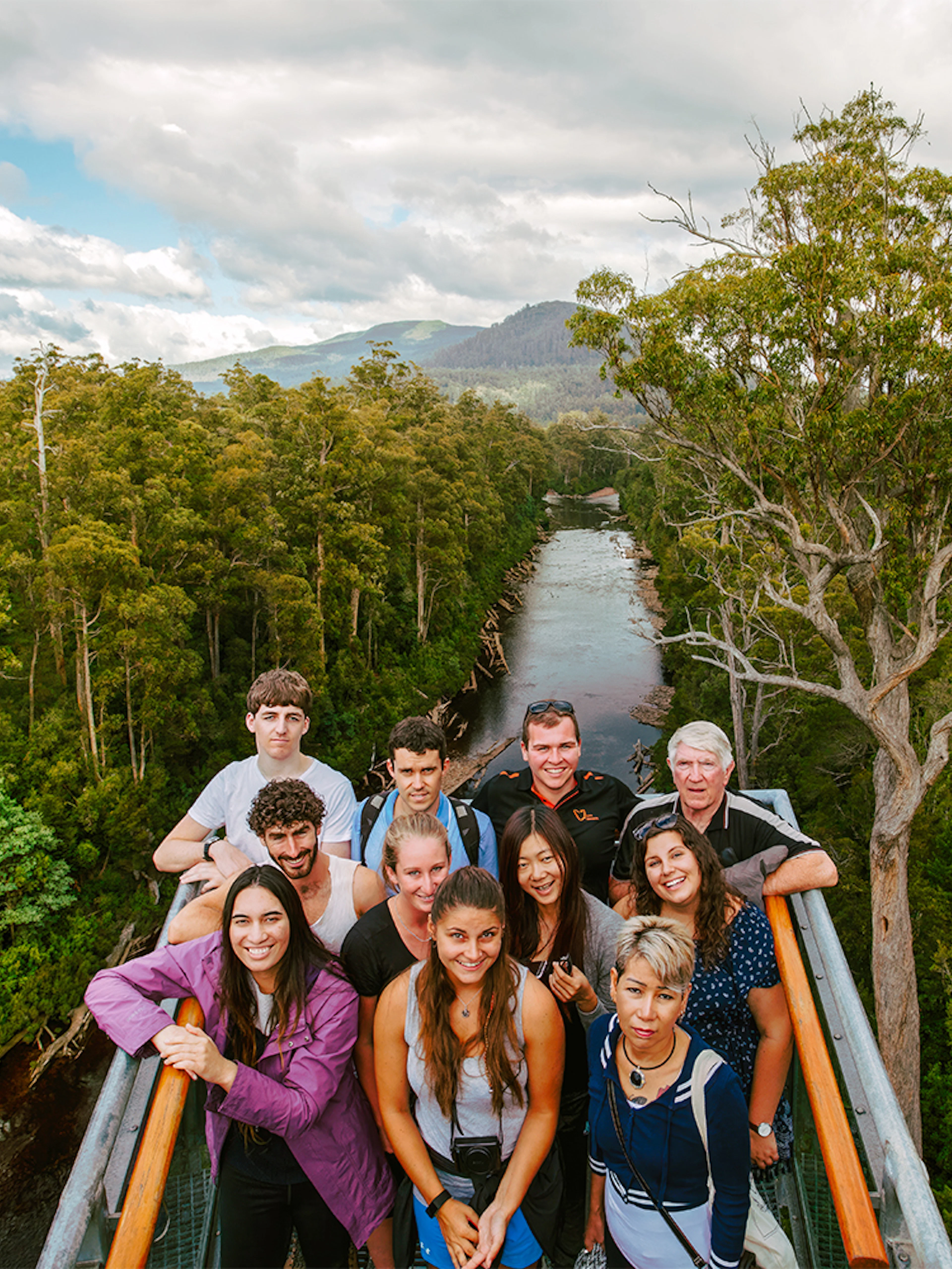 Group of tourists on Tahune Airwalk with forest and river view, Tasmania.