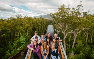 Group of tourists on Tahune Airwalk with forest and river view, Tasmania.