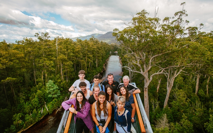 Group of tourists on Tahune Airwalk with forest and river view, Tasmania.