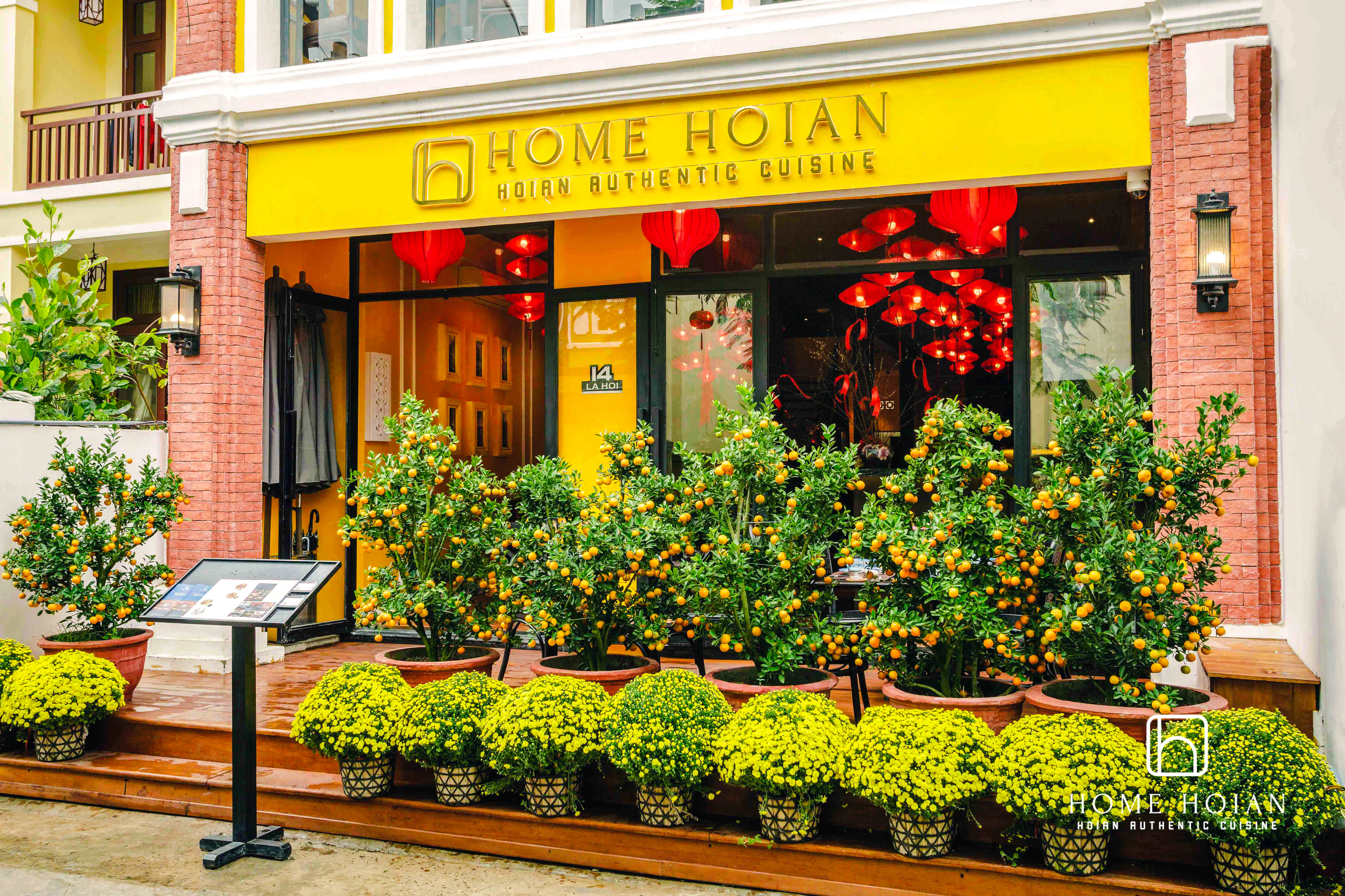 HOME Hoi An Restaurant entrance with orange trees and yellow flowers, Hoi An.