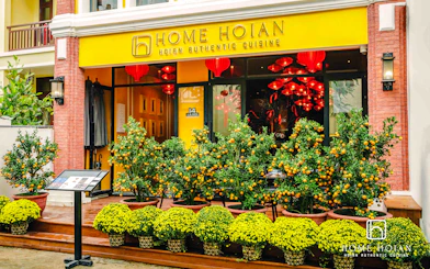 HOME Hoi An Restaurant entrance with orange trees and yellow flowers, Hoi An.