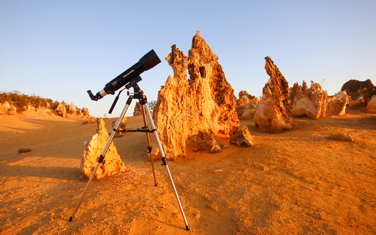 Telescope set up in Pinnacles Desert, Western Australia, with limestone formations.
