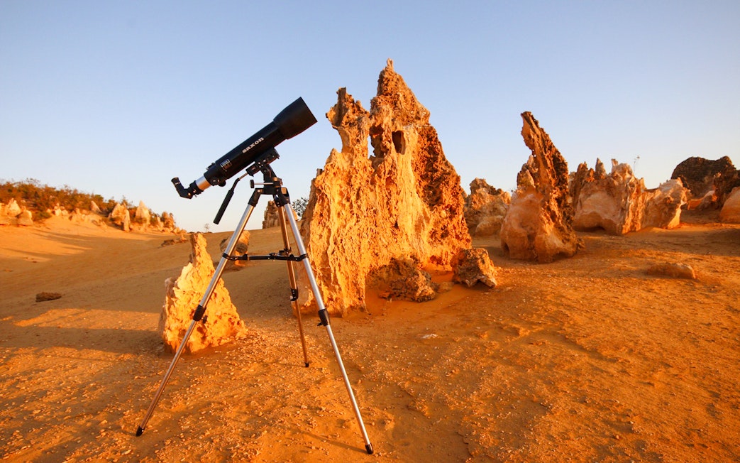 Telescope set up in Pinnacles Desert, Western Australia, with limestone formations.