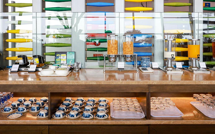 Breakfast buffet at SH Premium Lounge, Noi Bai International Airport, featuring cereals and beverages.