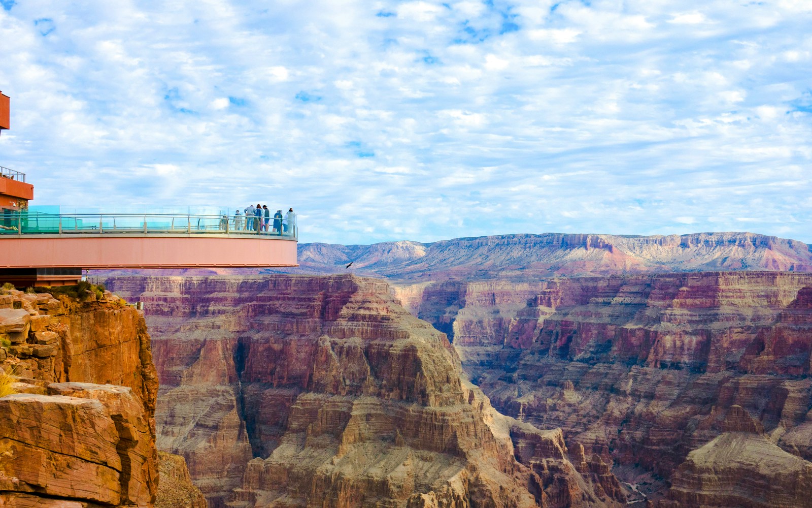 Helicopter flying over Grand Canyon with view of Skywalk glass observation bridge.