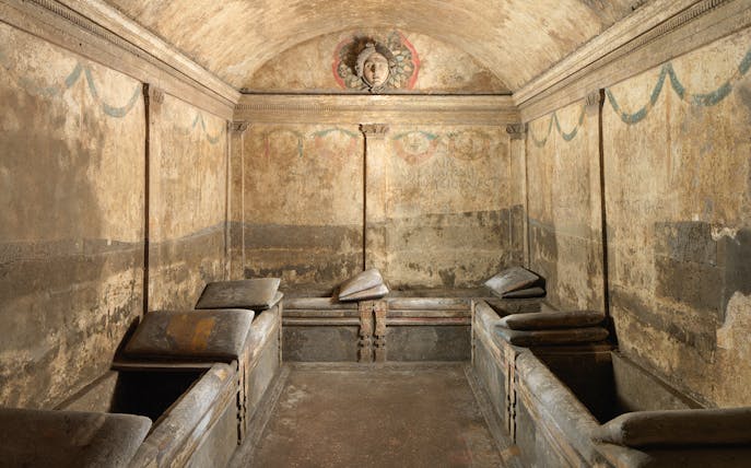Ancient burial chamber with stone sarcophagi at Ipogeo dei Cristallini, Naples.