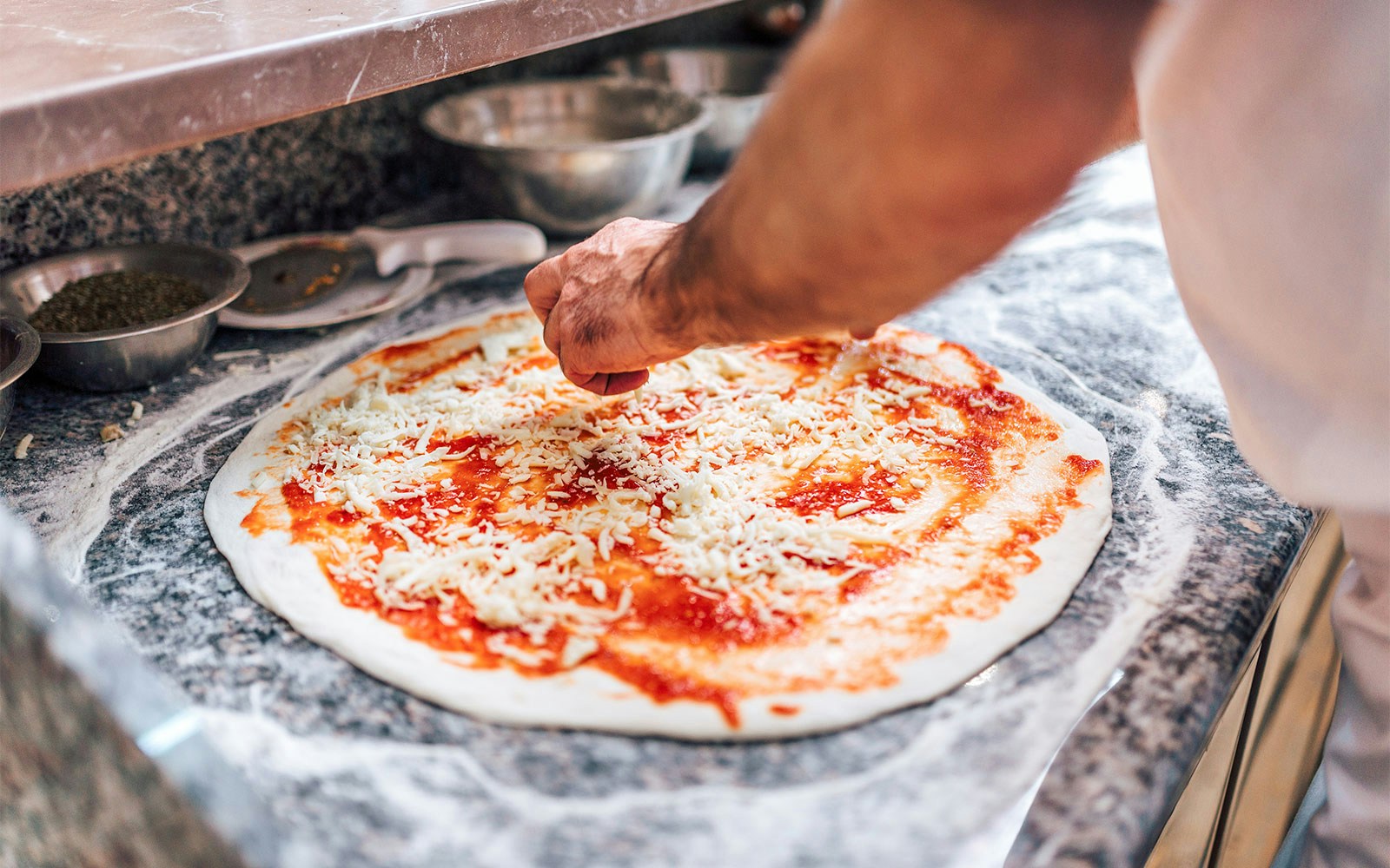 Chef preparing pizza on Dubai Creek luxury dhow dinner cruise.