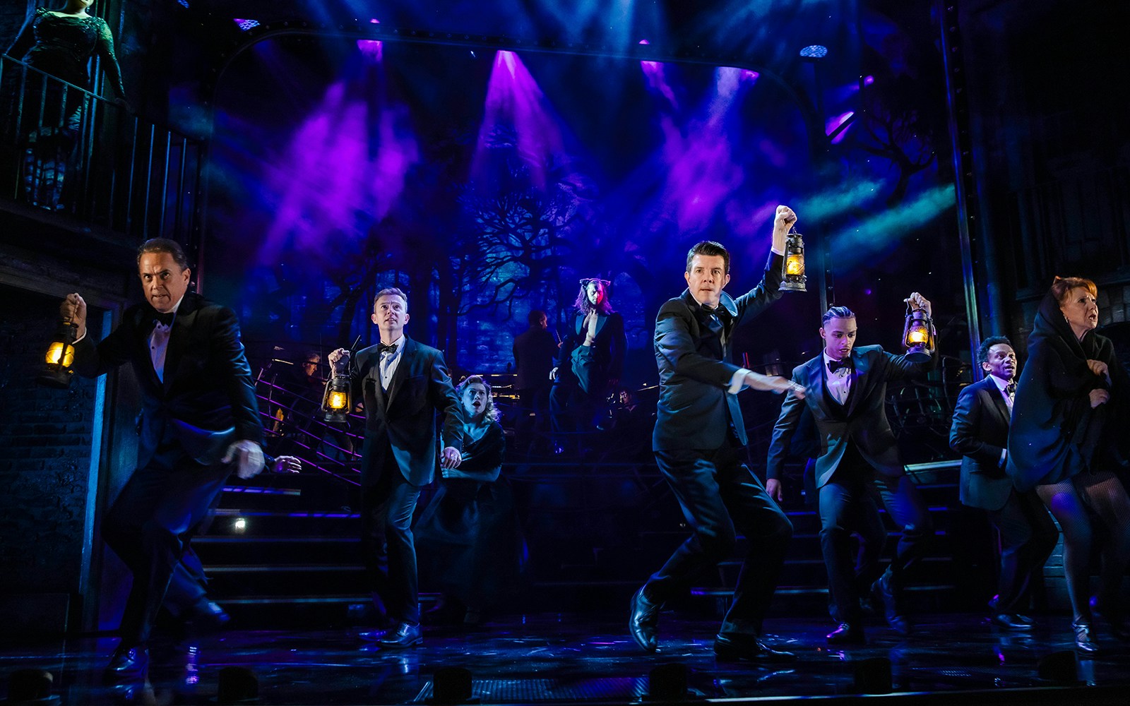 Performers on stage with lanterns in Stephen Sondheim's Old Friends show.