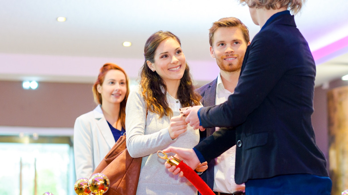 Couple receiving skip-the-line tickets at a venue entrance.