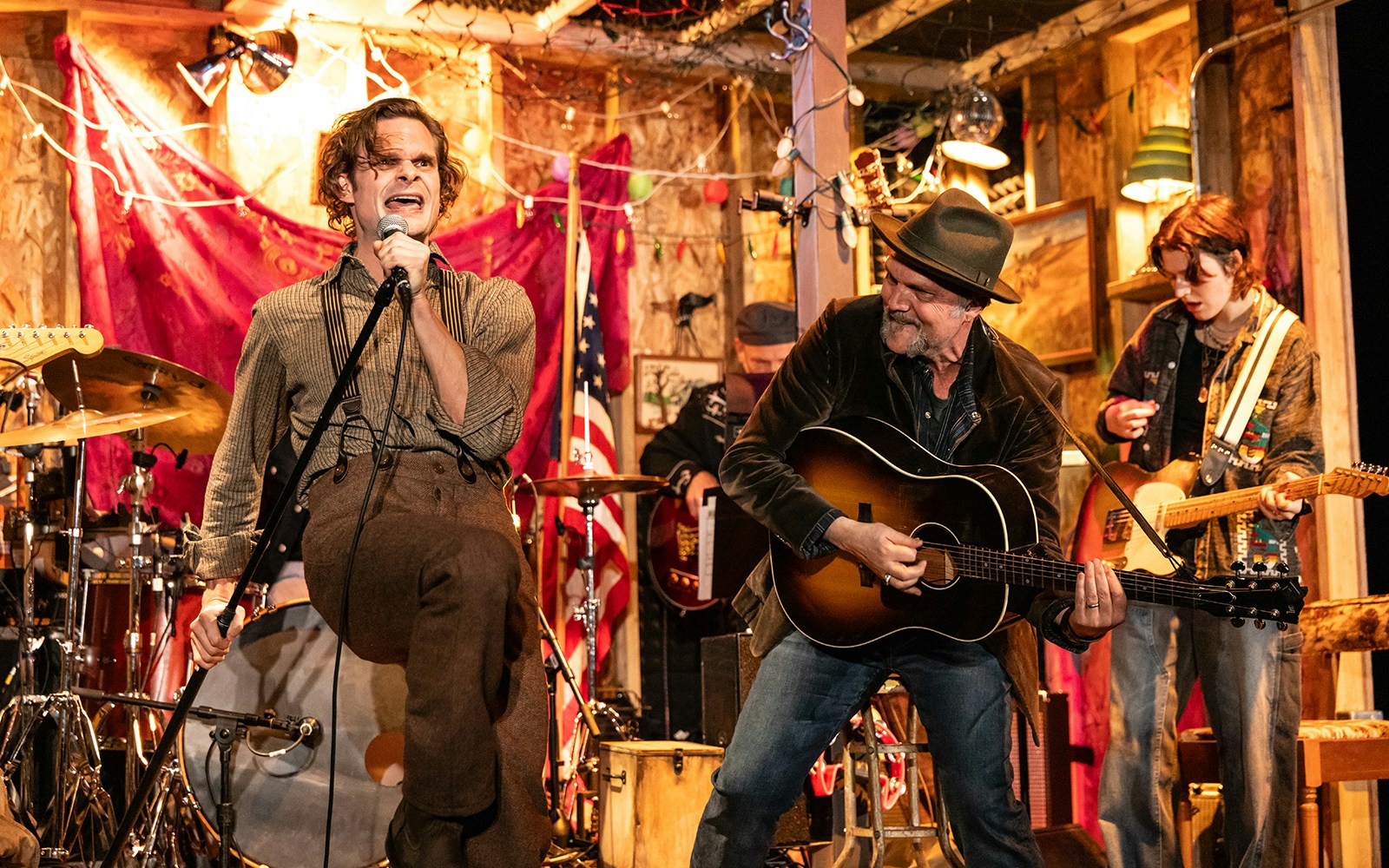 Band performing lively music on stage with a singer and guitarists, themed around Dead Outlaw.