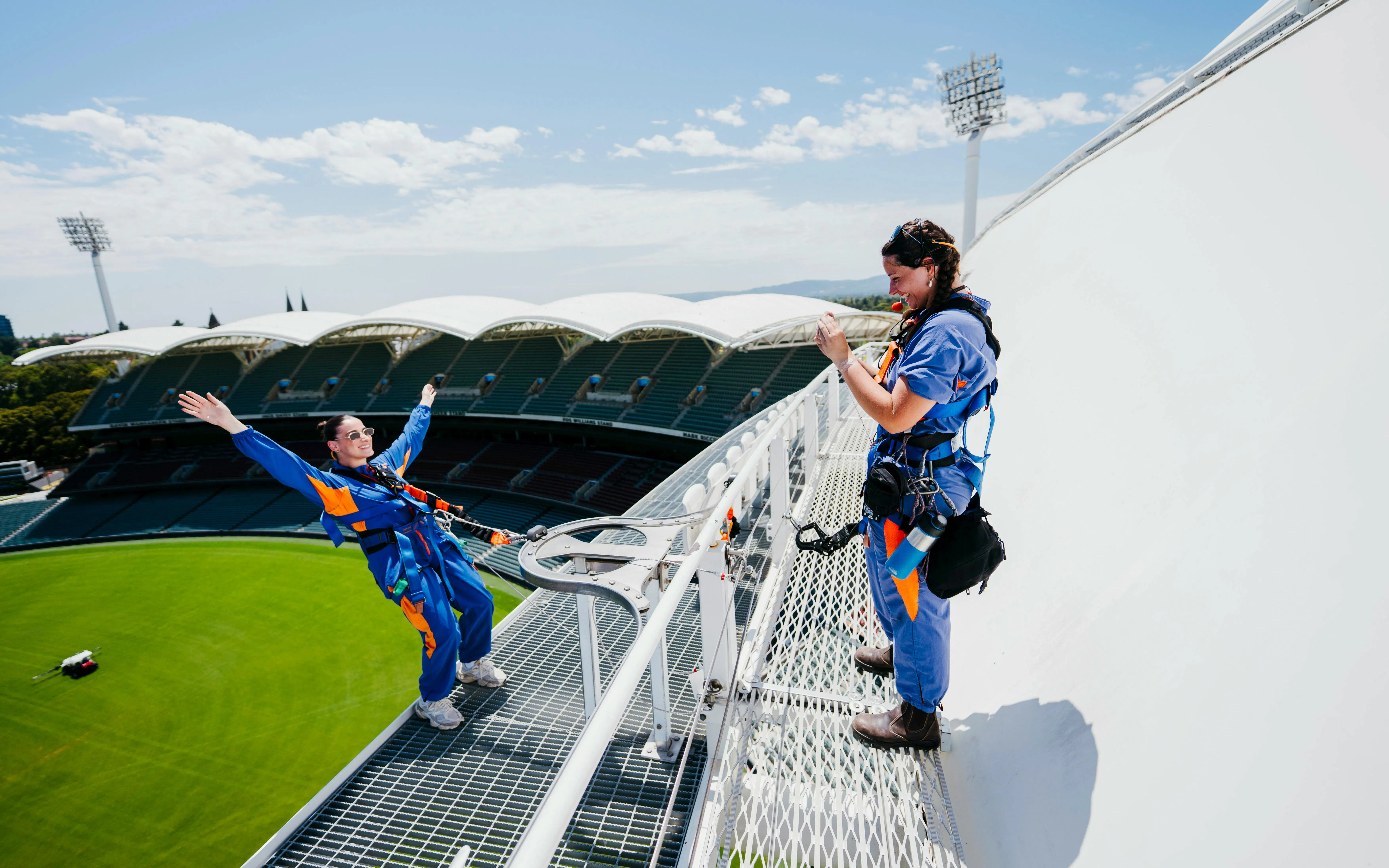 Participants on the Adelaide Oval roof climb with view of the stadium below.