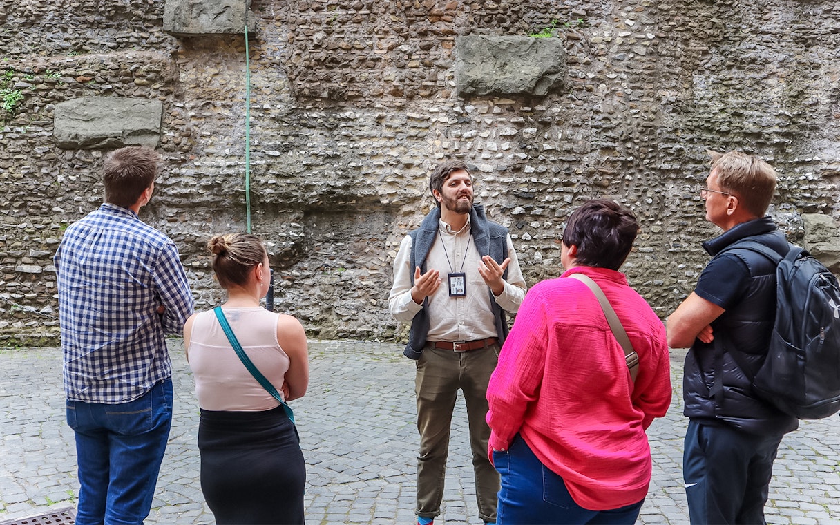 Tour guide explaining history to visitors at Castel Sant'Angelo, Rome.