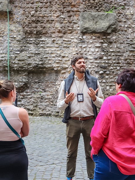 Tour guide explaining history to visitors at Castel Sant'Angelo, Rome.