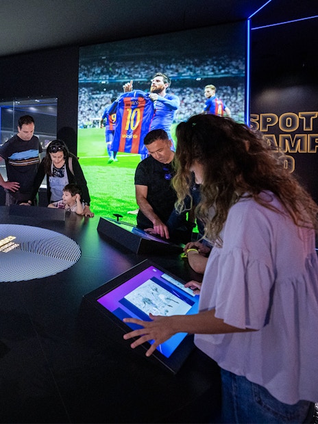 Visitors interact with digital displays at Camp Nou Barca Museum's immersive tour.