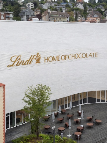 Lindt Home of Chocolate Museum exterior with outdoor seating area in Switzerland.