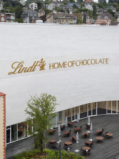 Lindt Home of Chocolate Museum exterior with outdoor seating area in Switzerland.