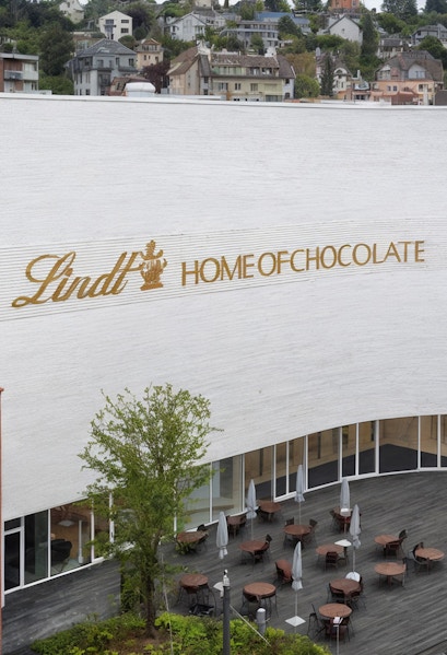 Lindt Home of Chocolate Museum exterior with outdoor seating area in Switzerland.