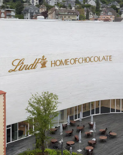 Lindt Home of Chocolate Museum exterior with outdoor seating area in Switzerland.