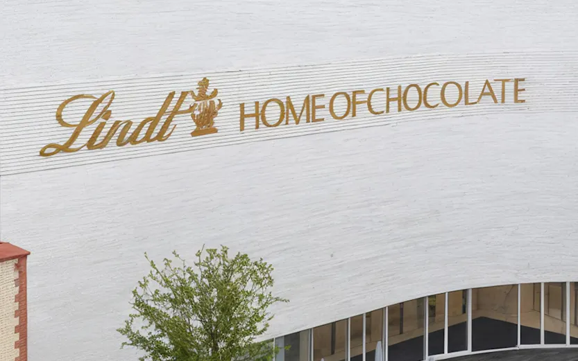 Lindt Home of Chocolate Museum exterior with outdoor seating area in Switzerland.