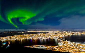 Northern lights over Tromso cityscape at night.
