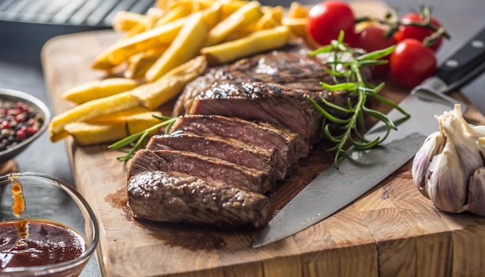 Steak and fries at The Guinea Grill, London, with tomatoes and garlic.