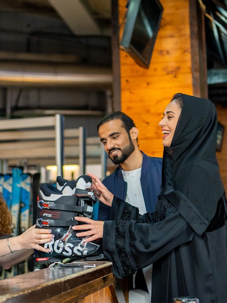 Ski Dubai visitors receiving ski boots from staff at Snow Park entrance.