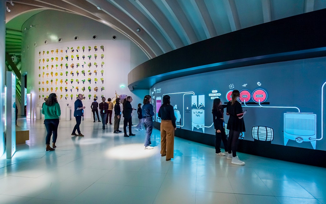 Visitors at Cité du Vin museum in Bordeaux on a self-guided audio tour with wine tasting.
