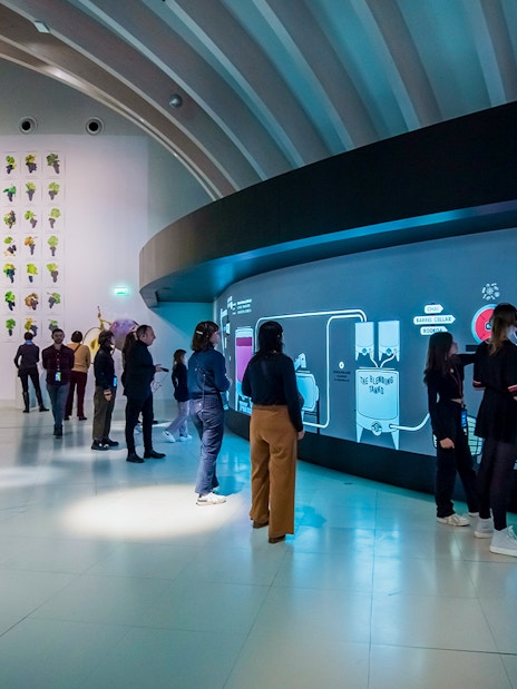 Visitors at Cité du Vin museum in Bordeaux on a self-guided audio tour with wine tasting.