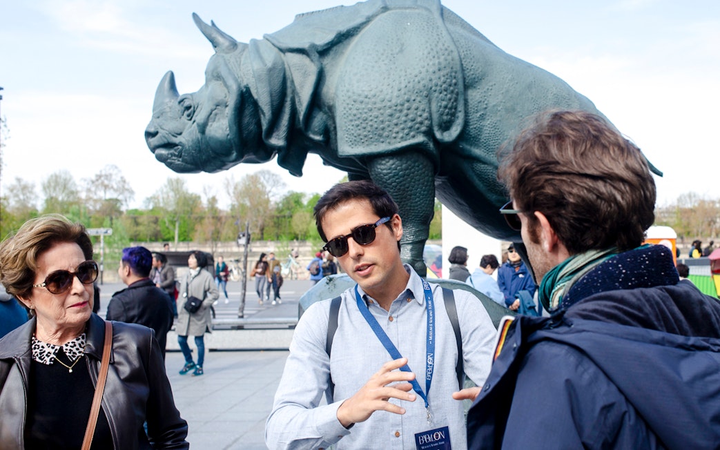 Guide with tourists in front of rhino statue outside Orsay Museum, Paris, France.