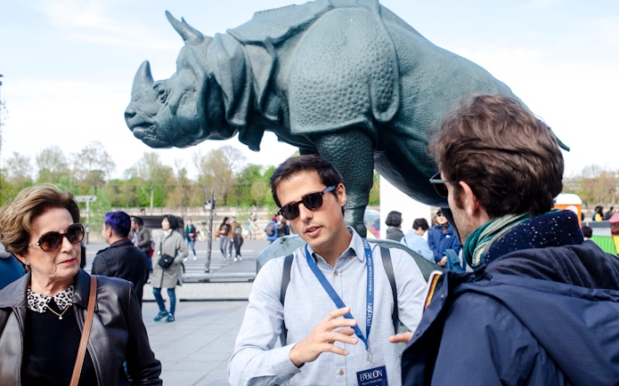 Guide with tourists in front of rhino statue outside Orsay Museum, Paris, France.
