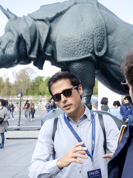 Guide with tourists in front of rhino statue outside Orsay Museum, Paris, France.