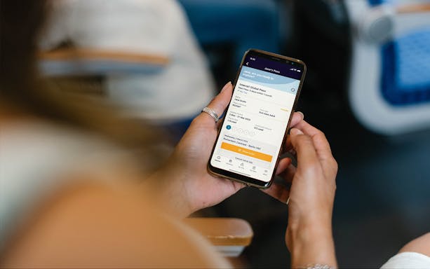 Person holding phone displaying Interrail Global Mobile Pass Flex booking.