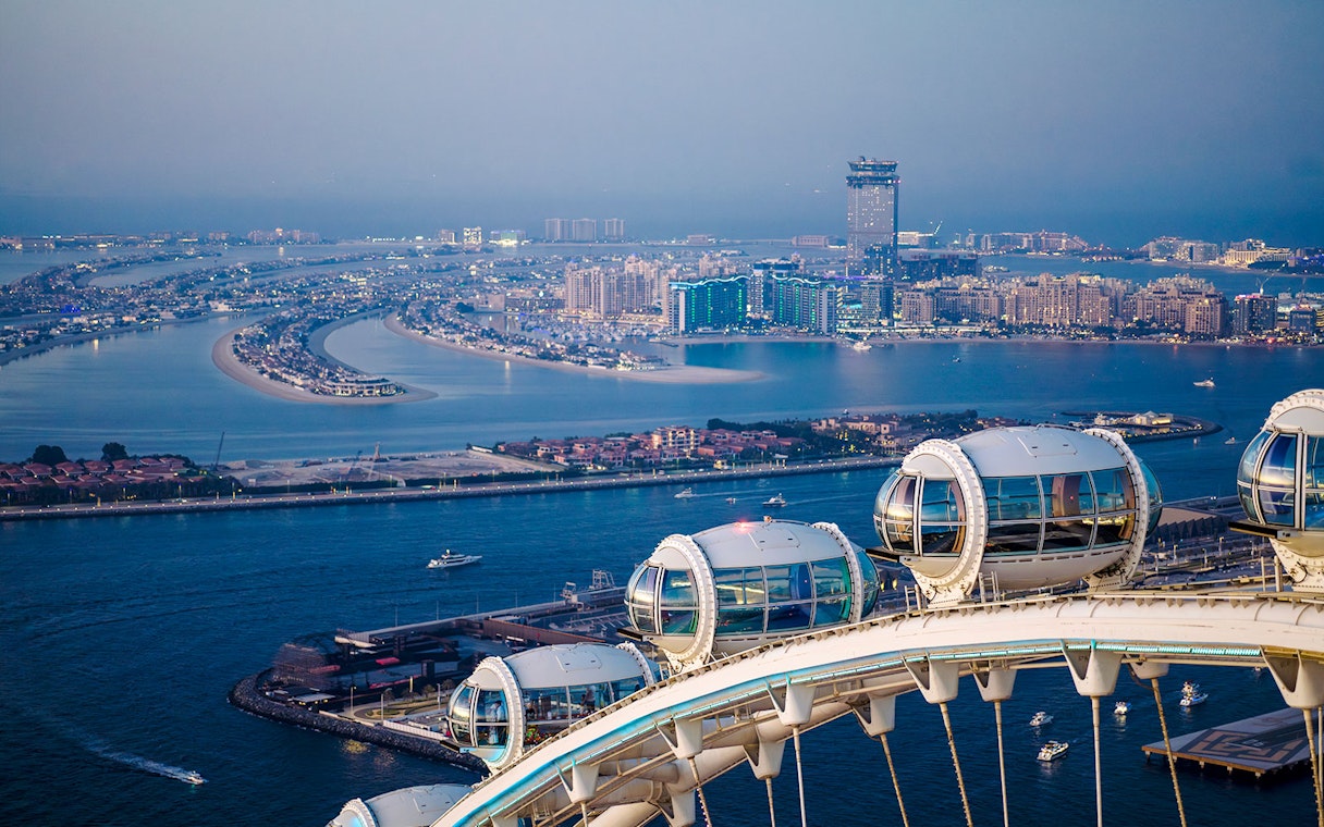 Ain Dubai pods overlooking Palm Jumeirah and Dubai skyline.