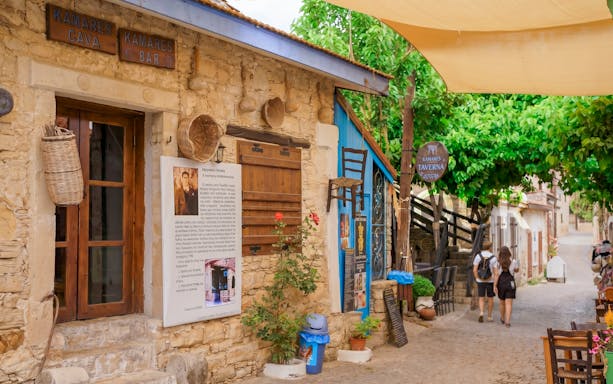 Stone village street with tavern signs in Troodos Mountains, Cyprus, part of Paphos tour.