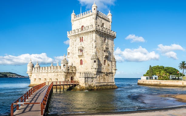 Belem Tower in Lisbon, Portugal, with a wooden walkway over the Tagus River.