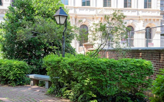 Historic Philadelphia garden with brick path and vintage lamp post.